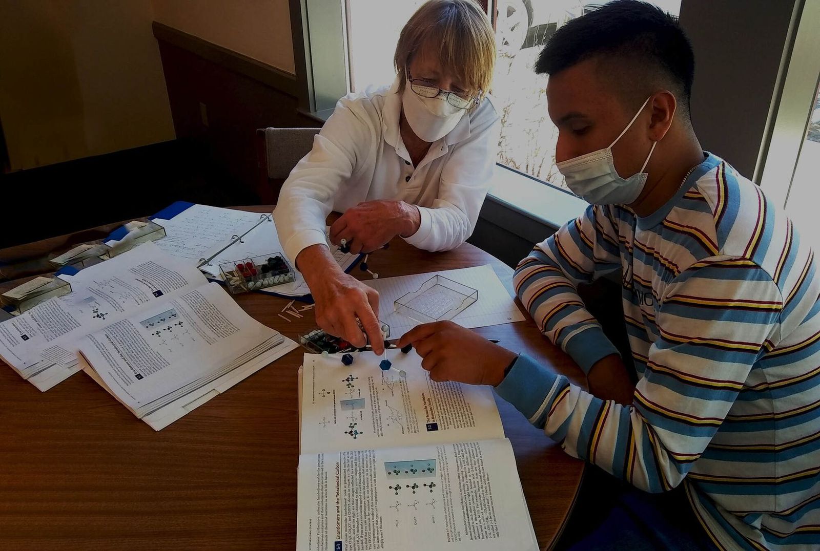 A LoyalTeach mentor and a student work through papers at a table