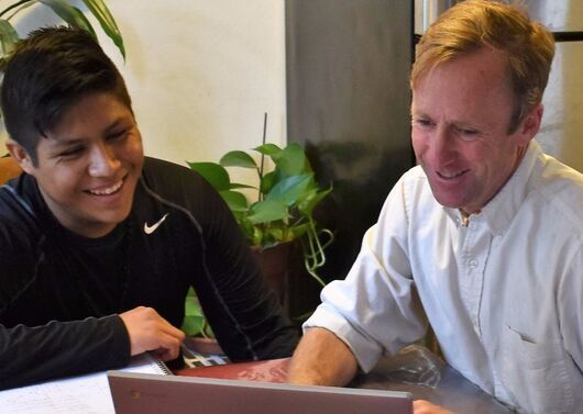 A LoyalTeach mentor and a student work together at a laptop