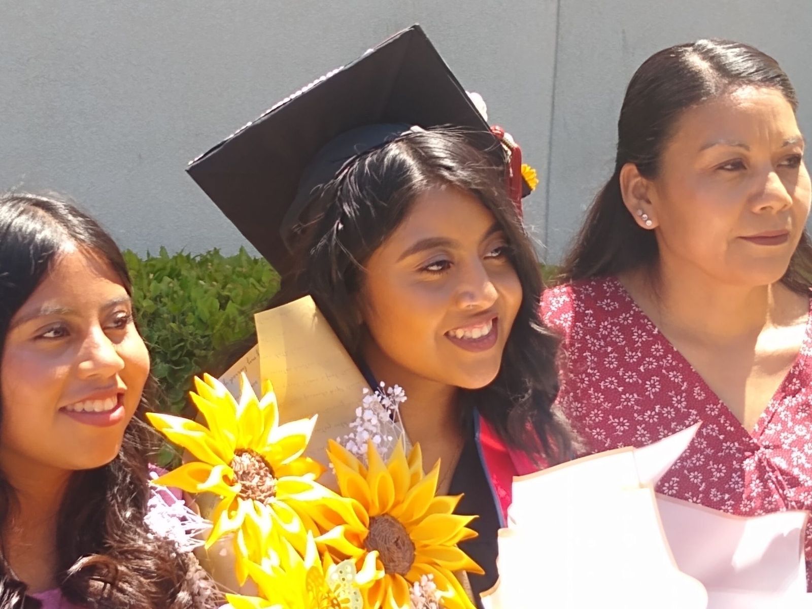 Yulisa with sunflowers and family at her CSU Fresno graduation
